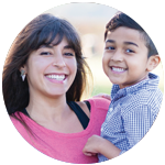 A mother holding up her son and smiling.